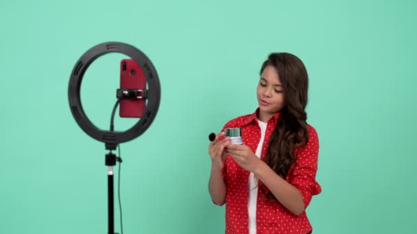 Tiener meisje maken video blog op smartphone proberen poeder en borstel, duim omhoog, make-up tutorial. — Stockvideo