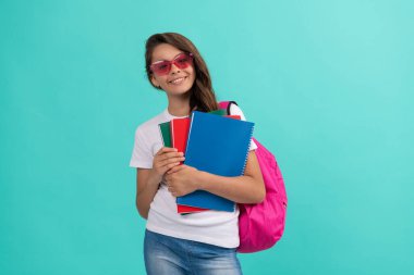 Sırt çantası ve güneş gözlüklü mutlu çocuk okula, okula gitmeye hazır.