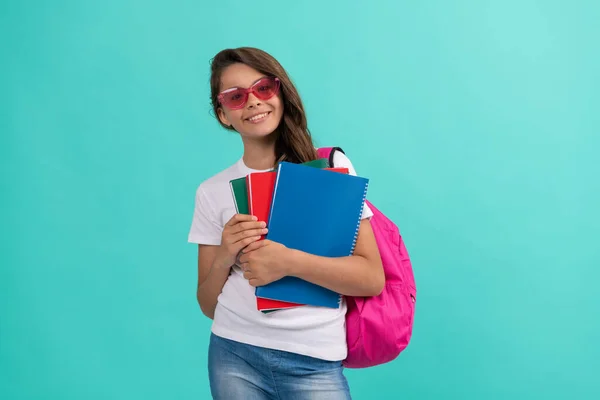 Šťastný kluk s batohem a copybookem ve slunečních brýlích připraven ke studiu ve škole, zpět do školy — Stock fotografie