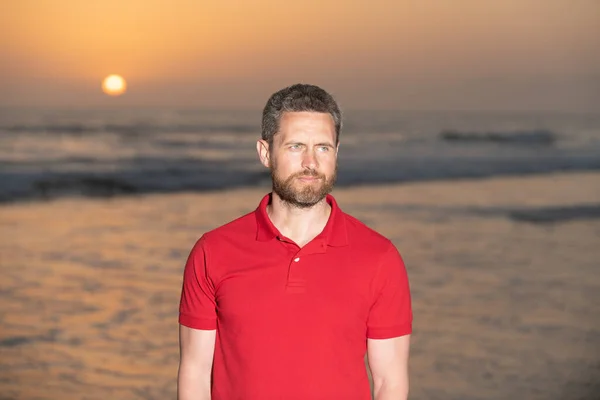 Tipo sem barba no fundo da praia. caucasiano na praia do nascer do sol. homem barbudo na camisa. — Fotografia de Stock