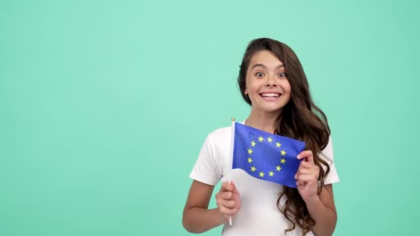 Garoto surpreso com cara feliz com bandeira azul união europeia mostrando polegar para cima, crianças no exterior — Vídeo de Stock