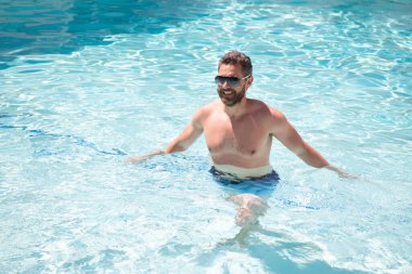 Yaz kaplıcası tatili. Havuzdaki mutlu yakışıklı adam. Havuz partisi.