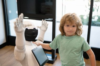 Akıllı çocuk modern eğitim ve yenilik için robot asistan teknolojisiyle iletişim kuruyor.