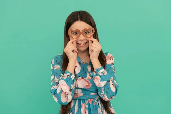 Happy girl enfant sourire portant des lunettes d'appui en forme de coeur pour la Saint-Valentin, Saint-Valentin. — Photo