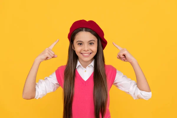 Menina adolescente feliz escola apontando dedo francês boina no fundo amarelo, estilo — Fotografia de Stock