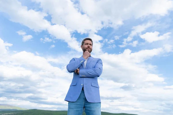 Красивый зрелый мужчина бизнесмен в формальном костюме проверить время на наручные часы на фоне неба, бизнес — стоковое фото