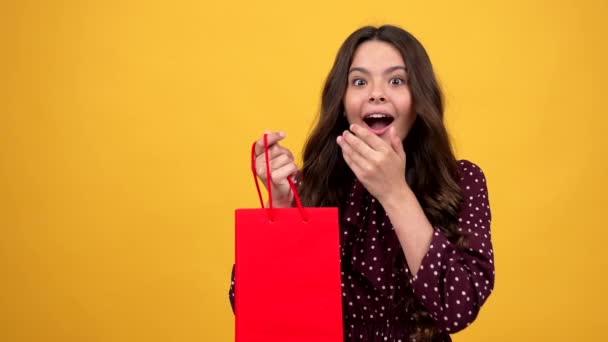 Curioso adolescente chica tomando pop es antiestrés juguete de la bolsa de compras regalo que muestra el pulgar hacia arriba, regalo. — Vídeos de Stock