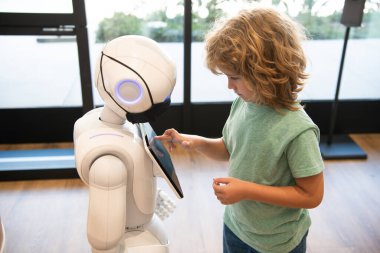 akıllı küçük çocuk robot asistan teknolojisiyle modern eğitim ve robot bilimi için iletişim kuruyor.