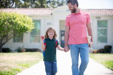 Eğitim. Okuldaki ilk günüm. Baba ve oğul okuldan dönüyorlar. Mutlu aile değeri.