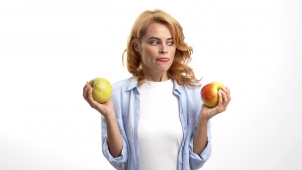Mujer hambrienta eligiendo manzana lamiéndose los labios y mordiendo fruta, hambre — Vídeo de stock
