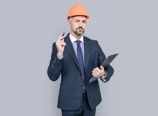 Fiducioso uomo d'affari tenere cartella. firmare il contratto. uomo di successo in hardhat prendere appunti. — Foto Stock