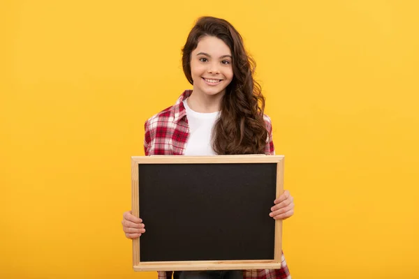 Happy teen girl hold school blackboard for copy space, advertisement — Fotografia de Stock