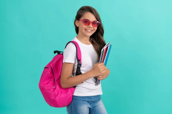 Happy teen girl with backpack and copybook in sunglasses ready to study at school, education — Stok fotoğraf