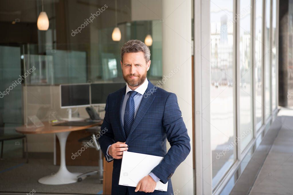 mature smiling businessman in businesslike suit hold wireless laptop outside the office, business