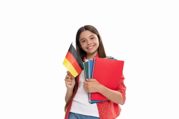 Χαρούμενο παιδί κρατά γερμανική σημαία και το σχολικό βιβλίο για τη μελέτη απομονωμένο σε λευκή, ξένη γλώσσα — Φωτογραφία Αρχείου