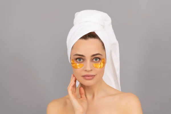 Érzéki hölgy frottírtörölköző használata arc arany szem tapasz a bőr, spa — Stock Fotó