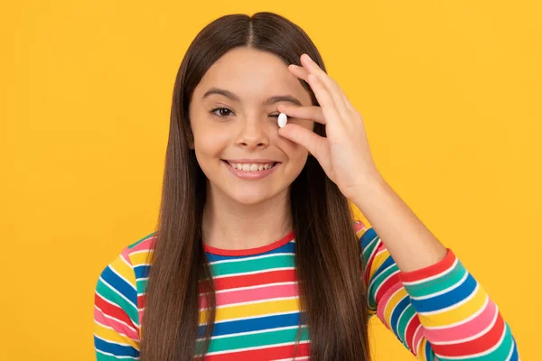 Tiener meisje met natuurlijke pil producten. presentatie van vitamineproducten. gelukkig kind met pil. — Stockfoto