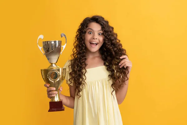 Niño sorprendido sosteniendo la copa campeona de oro como ganador, premio —  Fotos de Stock