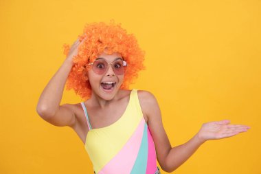 şaşırmış çocuk güneş gözlüğü ve mayo peruk takıyor ürün sunuyor, fotokopi alanı, sürpriz.