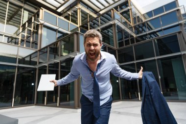 Bağıran adam şok olmuş ve duygusal olarak öfkeli görünüyor. Dizüstü bilgisayarı, öfkeyi...