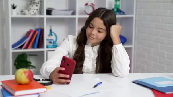 Feliz estudiante en uniforme escolar escribiendo y leyendo mensajes de texto en el teléfono inteligente, mensajería — Vídeos de Stock