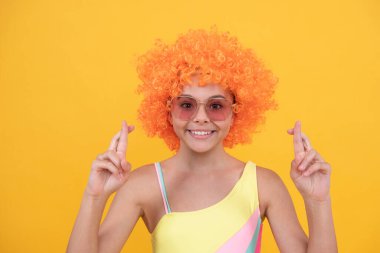 Güneş gözlüklü ve mayo giyen mutlu çocuk şans diliyor..