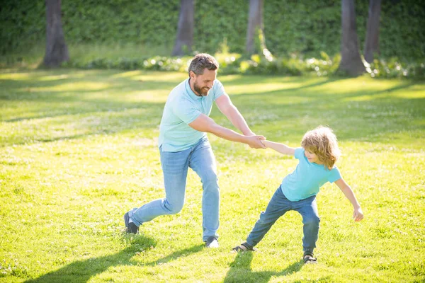 Счастливый отец и сын весело проводят лето на природе, в кругу семьи — стоковое фото