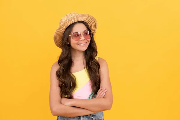 Gelukkig kind in de zomer stro hoed en bril heeft krullend haar op gele achtergrond, zomer — Stockfoto
