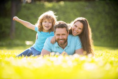 friendship. father mother and child on green park grass. friendly family have fun in summer