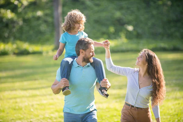 Foster care. Foster parents and son. Mother and child riding piggy back on father. Adoptive family — Stock Photo, Image