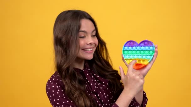 Criança feliz apresentando o produto e popping pop-lo brinquedo de silicone antistress, loja de brinquedos — Vídeo de Stock