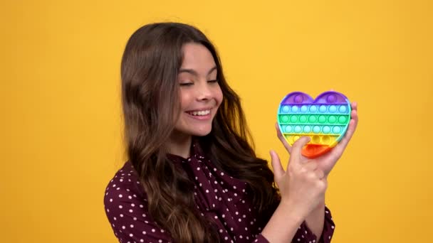 Enfant heureux présentant le produit et popping pop il jouet en silicone anti-stress, magasin de jouets — Video