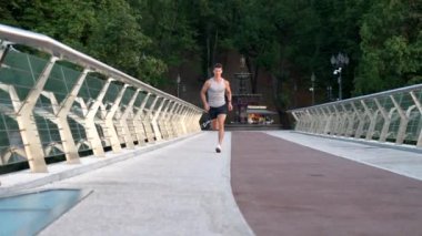 Spor giyim ve antrenman koşusunda koşan kaslı genç bir adam.