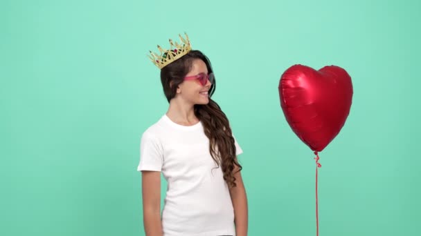 Šťastný dospívající dívka v slunečních brýlích a královna koruna cítil zmatený po srdeční balón letěl, náhlost. — Stock video