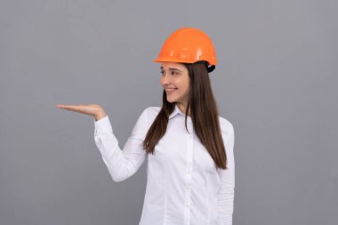 Miğferli girişimci. Güvenlik işi. İşçi bayramı. Mutlu kadın işçi ürün sunar..