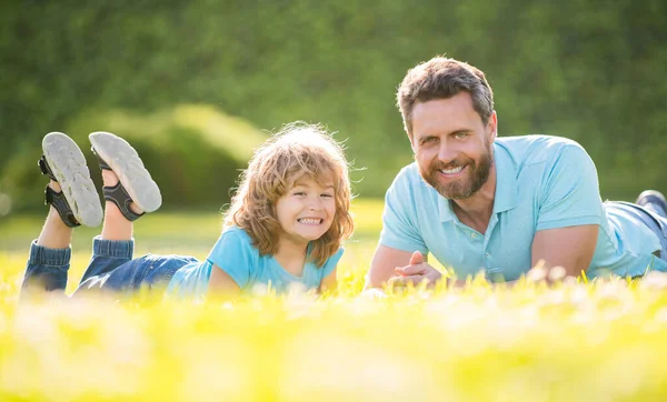 Feliz familia de padre e hijo niño relajarse en el parque de verano hierba verde, la paternidad — Foto de Stock