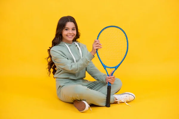 O miúdo de fato desportivo tem raquete. criança com raquete. menina adolescente relaxar após o treino desportivo. — Fotografia de Stock