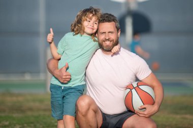 Mutlu baba oğul basketbol oynuyorlar açık havada, babalıkla.