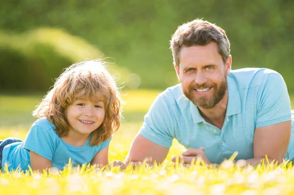 Happy family portrait of father and son child relax in summer park green grass, family value — Foto de Stock