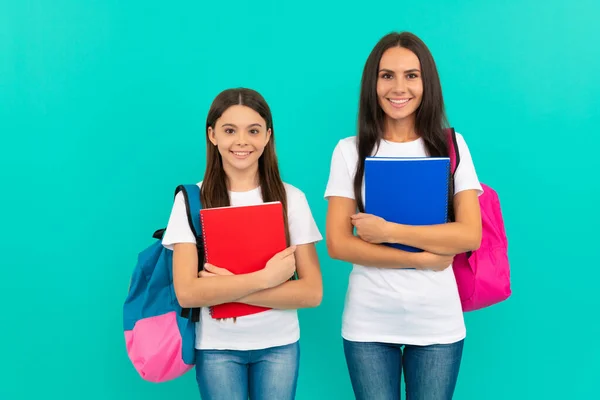 Hija feliz alumno y madre o maestro tienen libro de trabajo de la escuela para estudiar, volver a la escuela — Foto de Stock