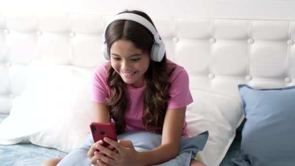 Chica adolescente feliz hablando en el teléfono celular en línea en los auriculares, dispositivo inalámbrico — Vídeo de stock