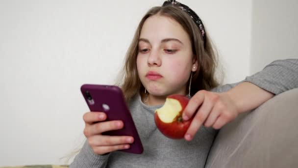 teen dívka jíst jablko při chatování na smartphone, dětství