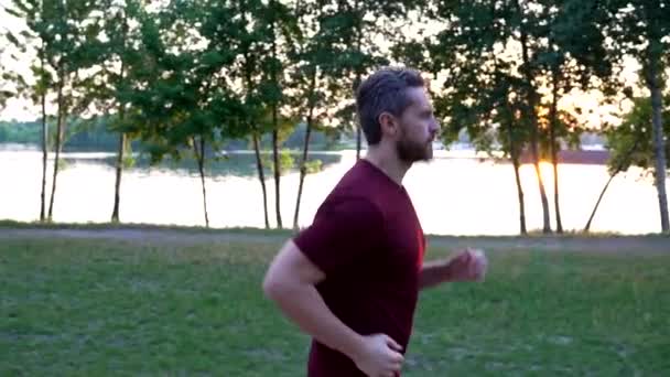 Homem maduro saudável em sportswear correndo no rio ao ar livre, vida saudável — Vídeo de Stock