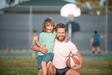 Mutlu baba ve oğul dışarıda basketbol oynuyor, aile içinde.