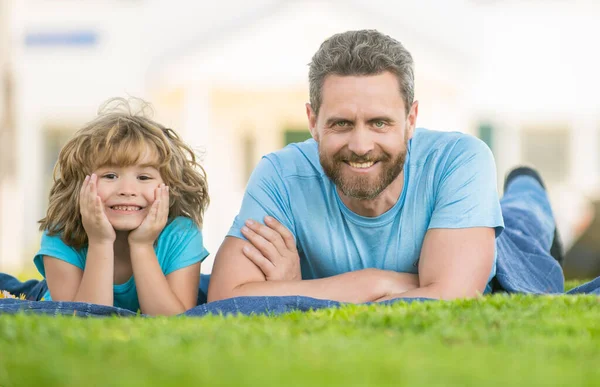Padre feliz con el niño relajarse juntos en la hierba verde parque, familia —  Fotos de Stock