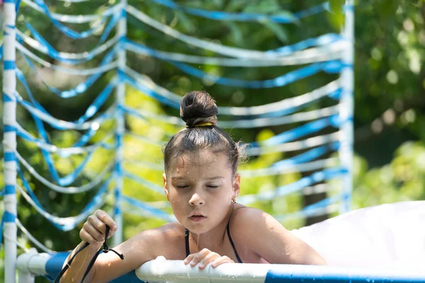 Дитина мокра дівчина насолоджується охолодженням у відкритому басейні в сонячний літній день, охолодження — стокове фото