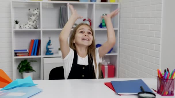 Счастливая школьница весело играла с бумажным самолетом на уроке в классе, счастье — стоковое видео