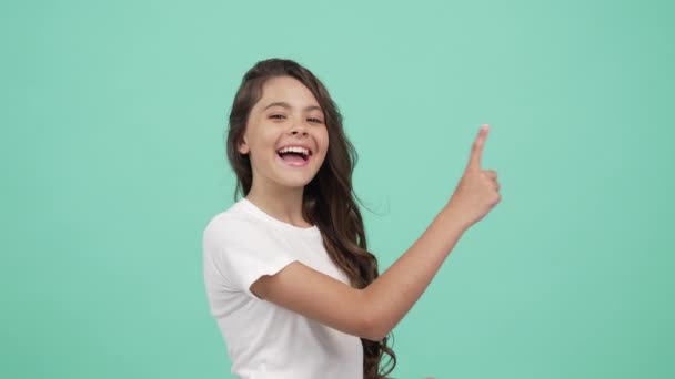 Niño en movimiento con la cara feliz bailando y dirigiendo los dedos diferentes lados del dedo en la cámara — Vídeos de Stock