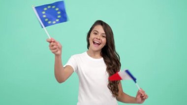 Mavi arka planda Avrupa Birliği ve Fransız bayrağı sallayan mutlu çocuk, Fransa tatili