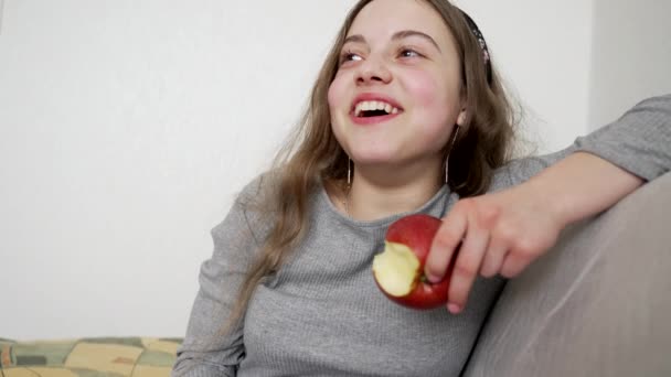 Niño feliz comiendo manzana y riendo de broma, felicidad — Vídeo de stock
